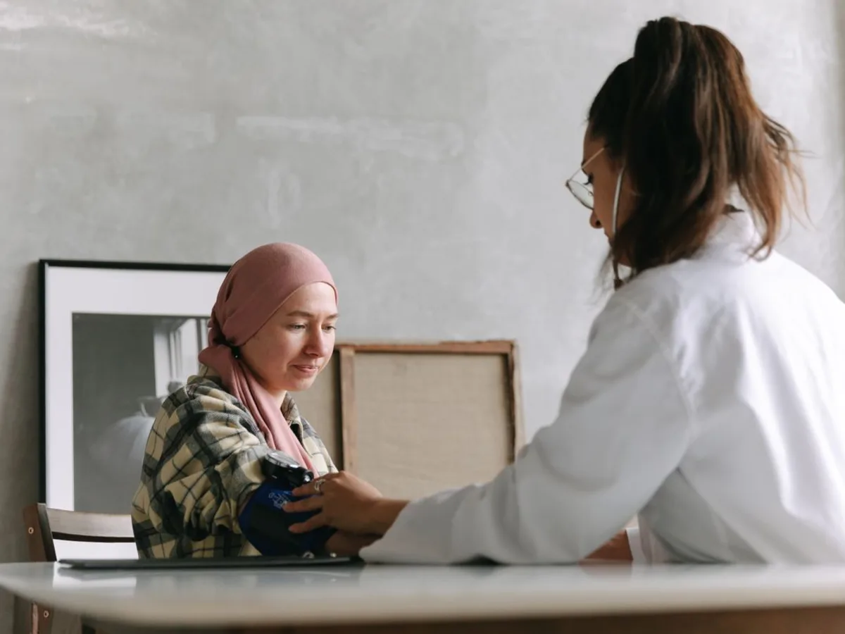Clinician checking a patient blood pressure during a preventive-care visit.